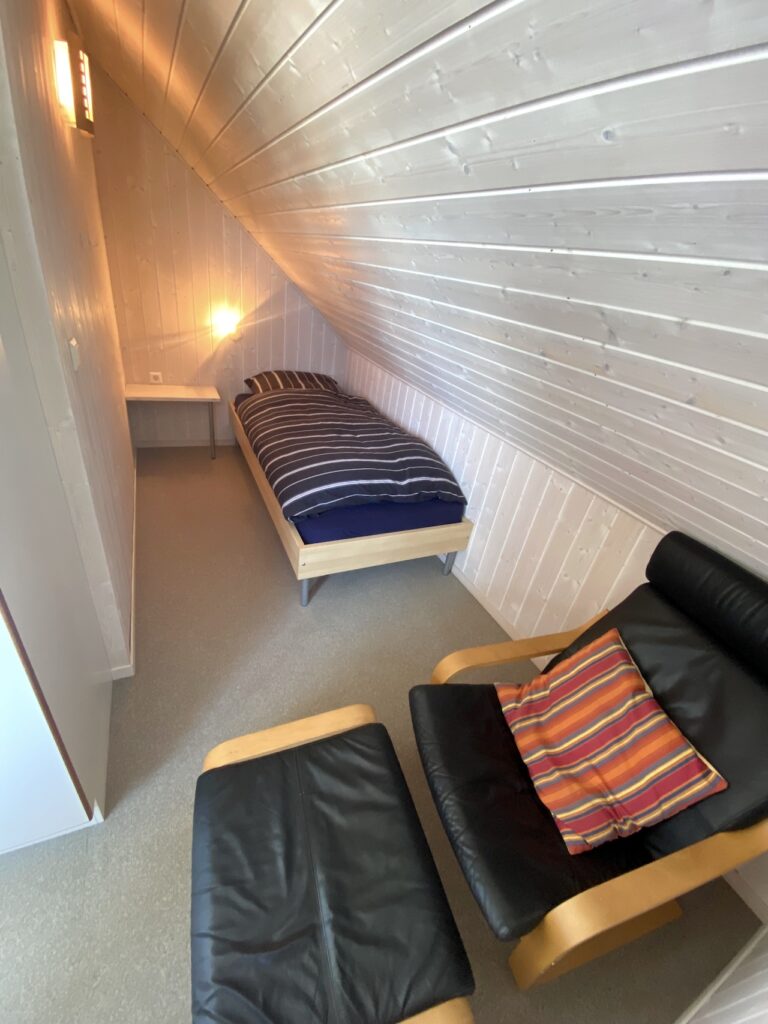 Ferienhaus WackerMagic Schlafzimmer Einzelbett und Lederstuhl